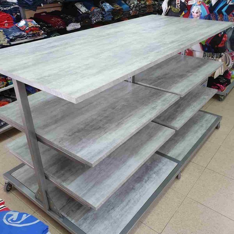 Una mesa de madera con cuatro estantes en una tienda.