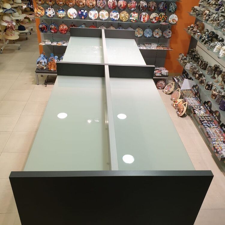 Una mesa en una tienda con platos en la pared detrás de ella.