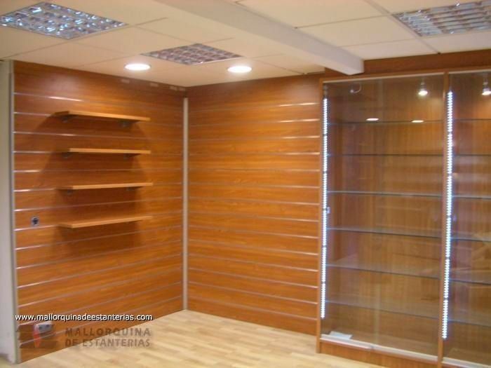 Una habitación con paredes revestidas de madera y estantes de vidrio.