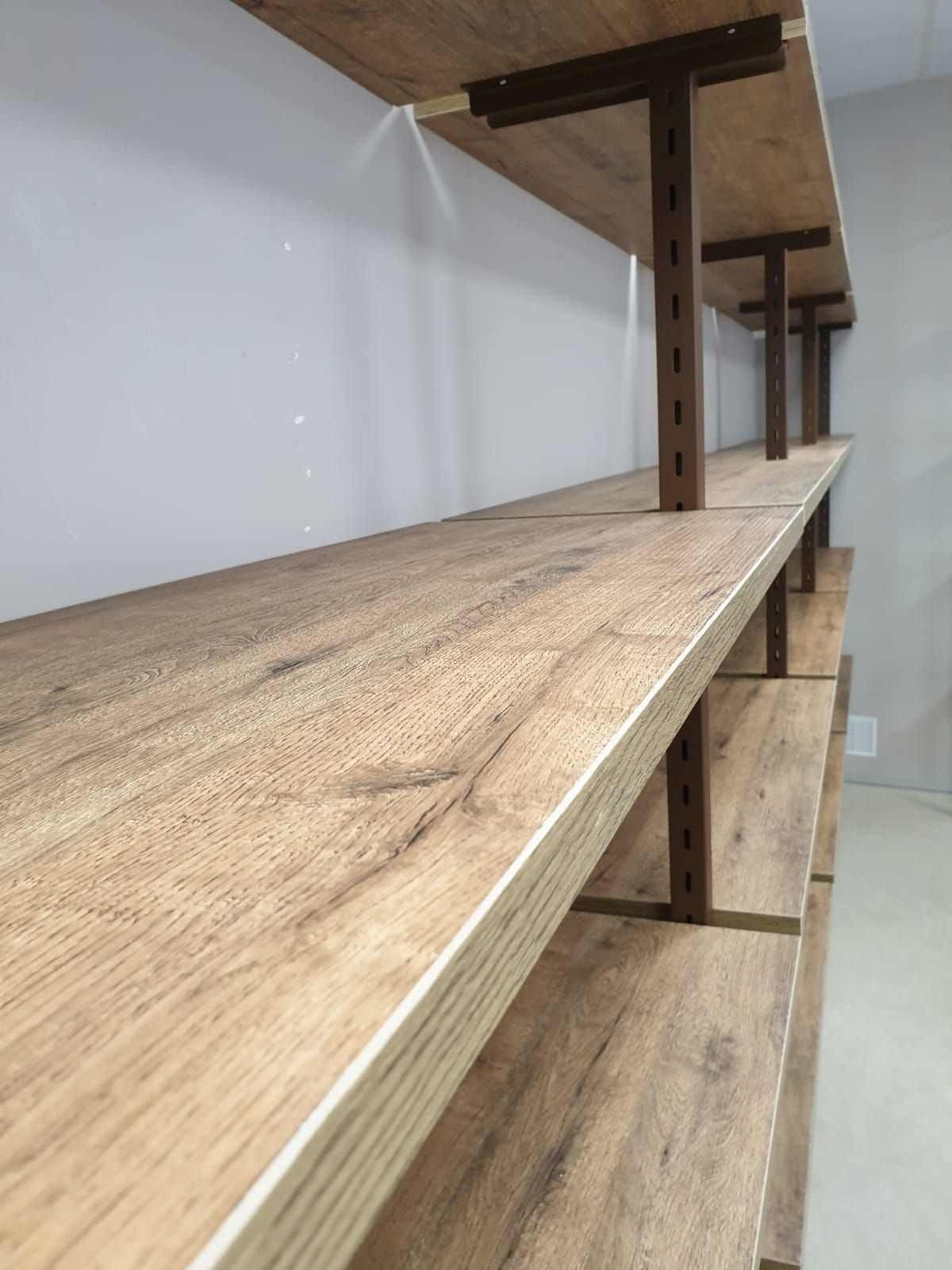 Una fila de estantes de madera contra una pared blanca.