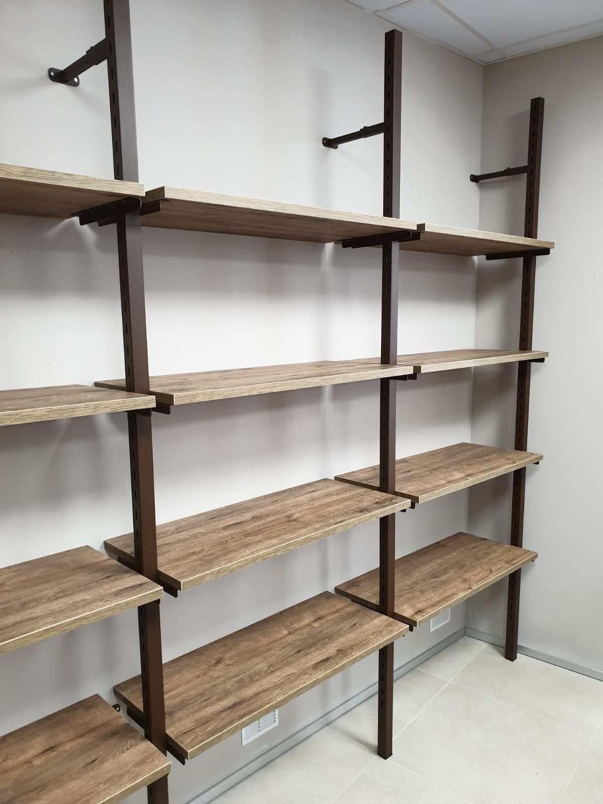 Una habitación con una fila de estantes de madera contra una pared blanca.