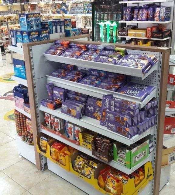 Un estante de una tienda lleno de muchos dulces, incluyendo Milka.