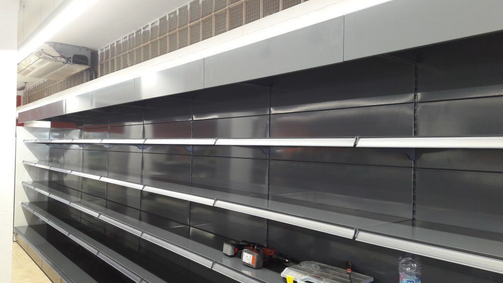 Una fila de estantes vacíos en una tienda.