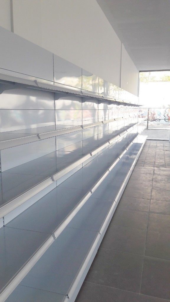 Una larga fila de estantes vacíos en una tienda.