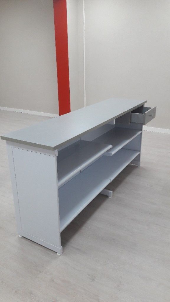 Un escritorio blanco con un cajón debajo en una habitación.