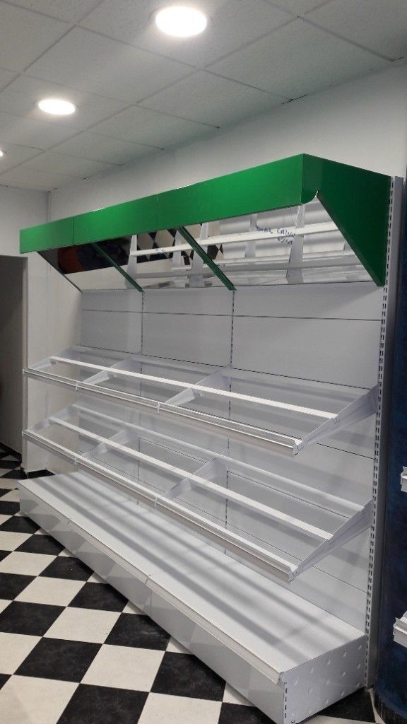 Un estante de tienda vacío con una tapa verde y un suelo a cuadros.