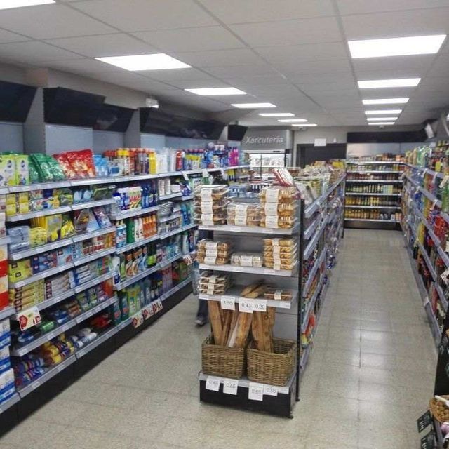 El interior de una tienda de comestibles con muchos estantes.