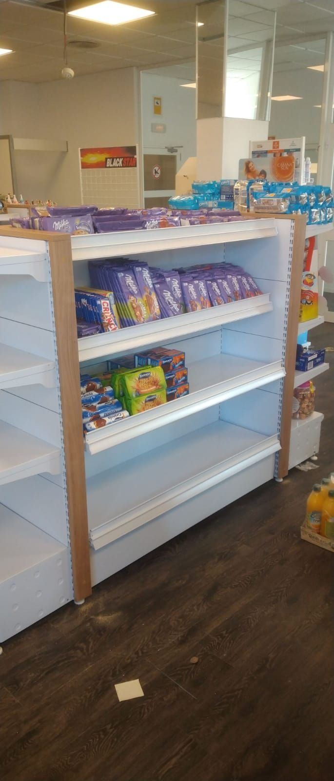 Un pasillo de tienda con estantes vacíos llenos de bocadillos.