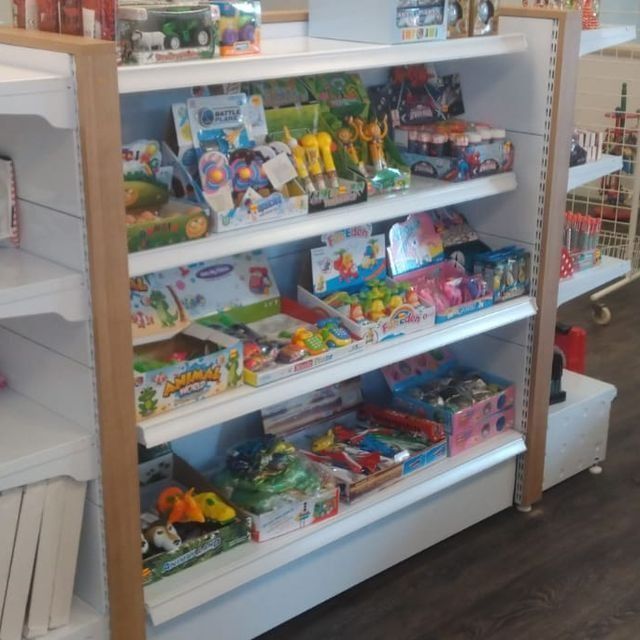 Un estante de una tienda lleno de muchos juguetes, incluida una rana.