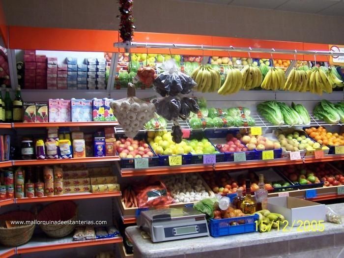 Una tienda de comestibles llena de frutas y verduras, incluidos plátanos.