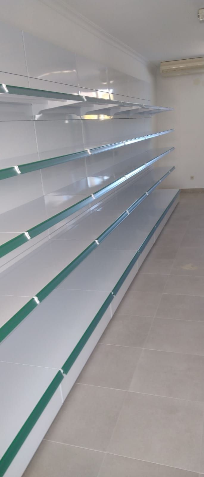 Una fila de estantes vacíos con rayas verdes en una tienda.