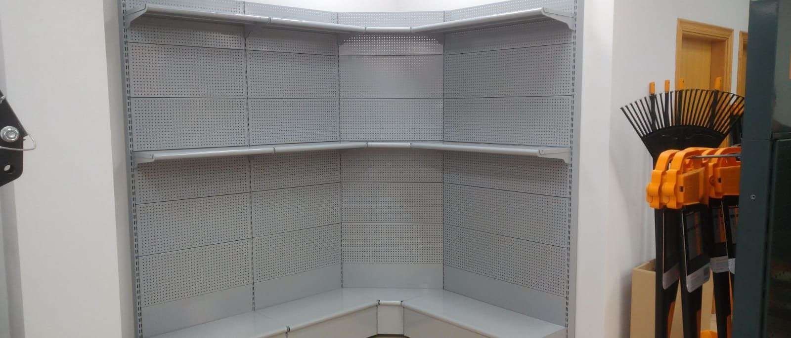 Una habitación con muchos estantes y un montón de herramientas en la pared.