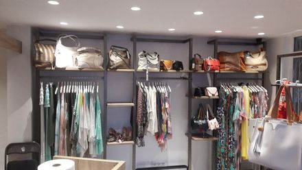 Una tienda llena de mucha ropa y bolsos