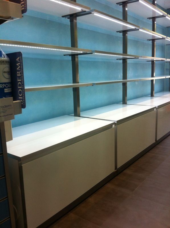 Una fila de estantes vacíos con un cartel de Bioderma al fondo.