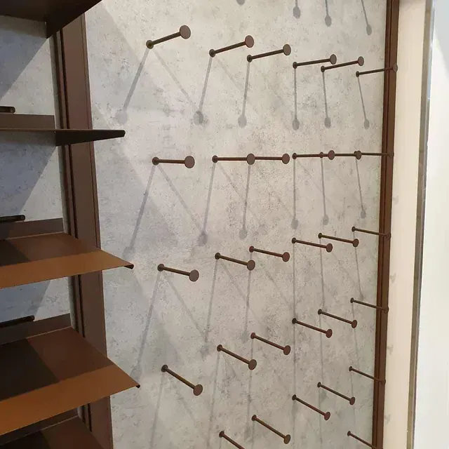 Una pared con un montón de clavos en ella