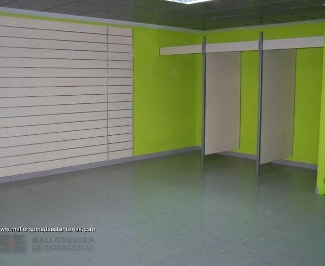 Una habitación vacía con paredes verdes y un suelo gris.