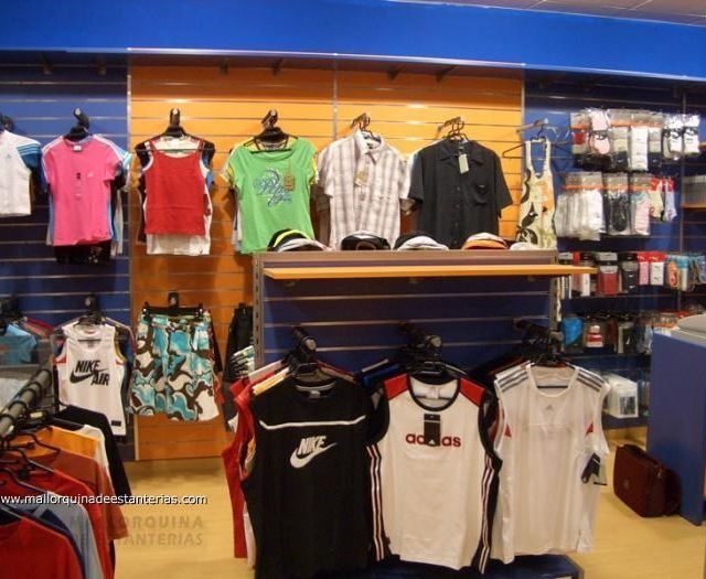 Una exhibición de camisetas, incluida una que dice adidas.