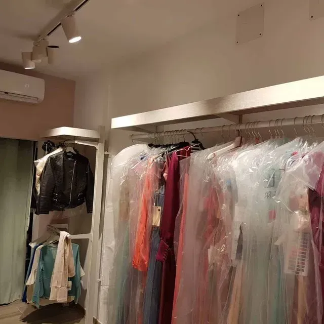 Un armario lleno de ropa envuelta en bolsas de plástico