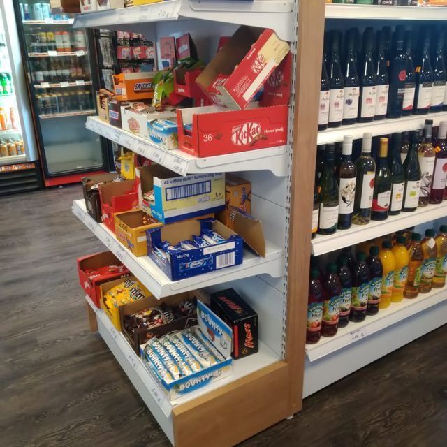 Un estante de una tienda con una caja de KitKat encima