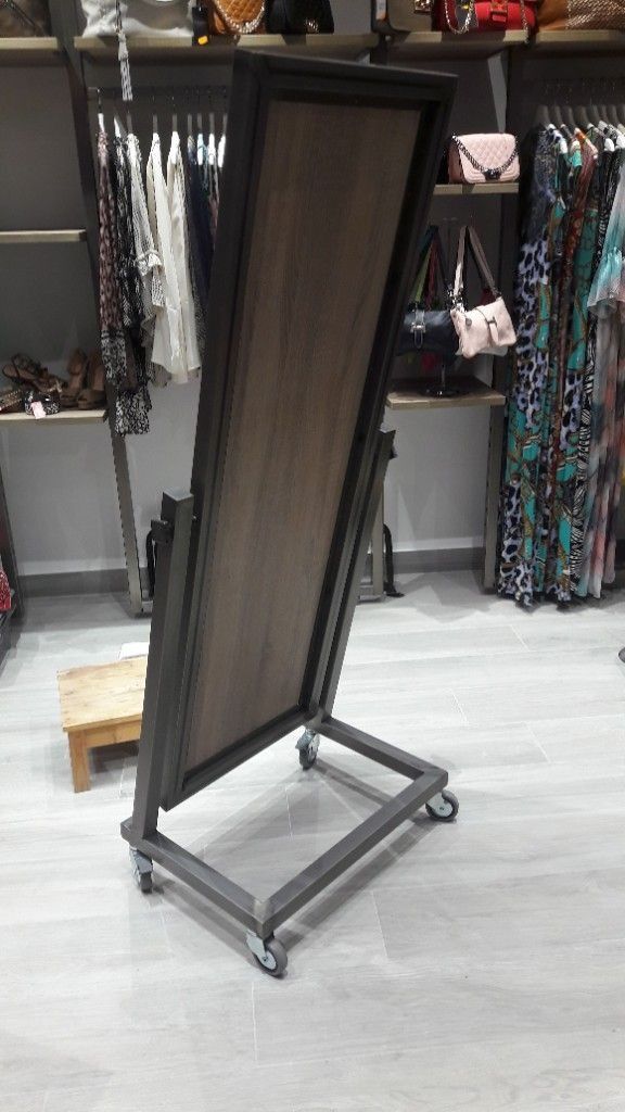 Un espejo con ruedas está en un armario en una tienda.