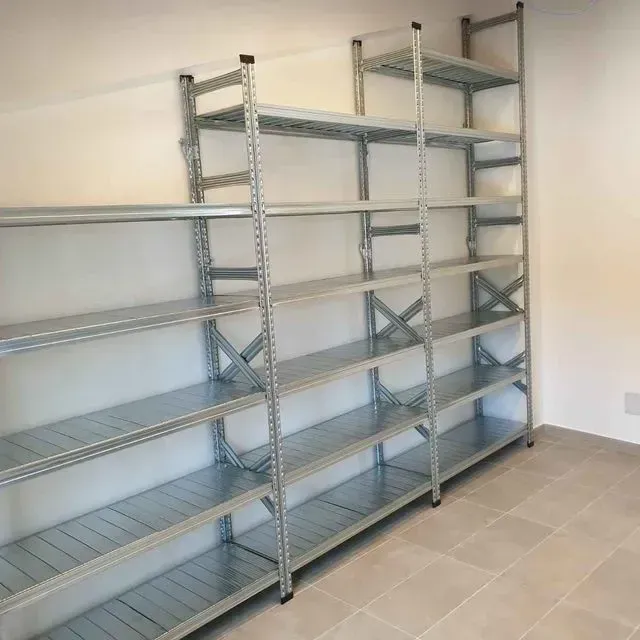 Una fila de estantes de metal contra una pared blanca.