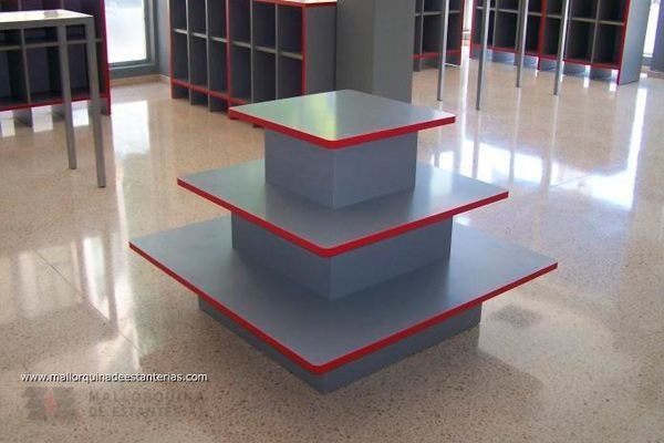 Un estante gris con borde rojo se encuentra en una habitación.