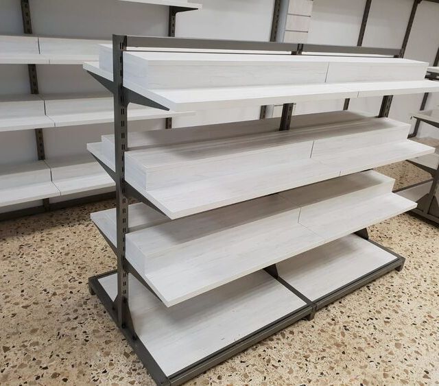 Una fila de estantes vacíos en una tienda con estantes blancos.