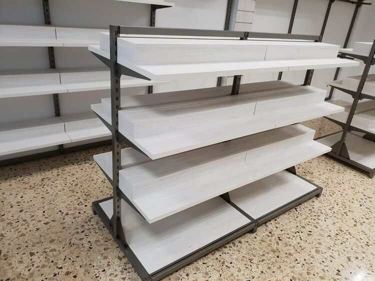 Una fila de estantes vacíos en una tienda con estantes blancos.