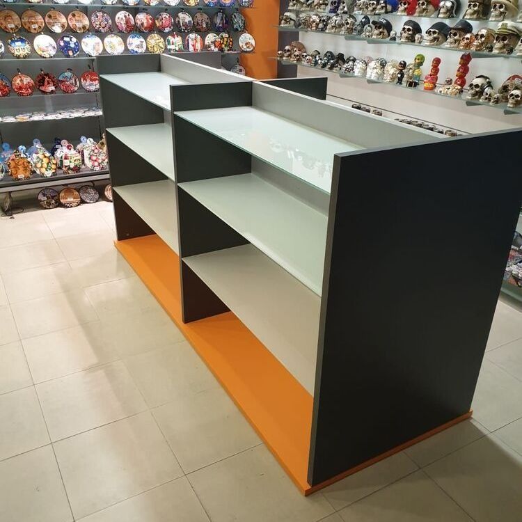 Un estante en una tienda con calaveras en la pared detrás.