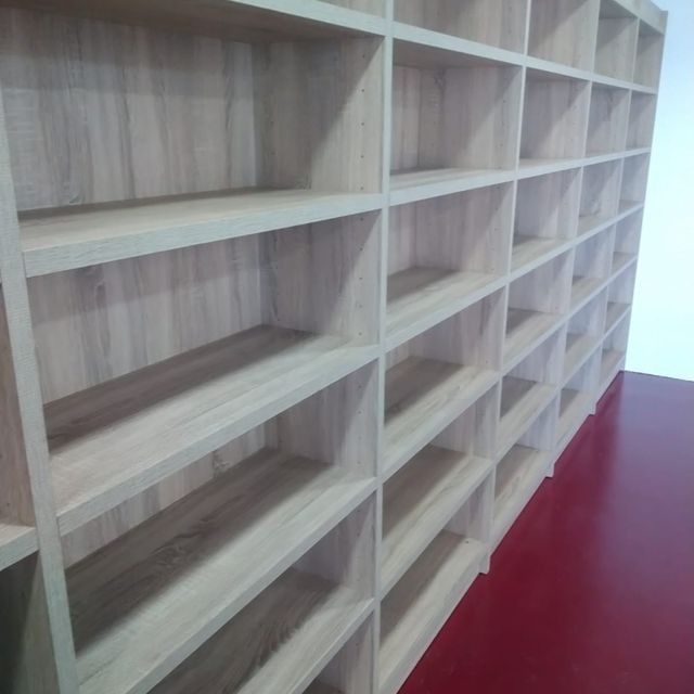 Una fila de estantes de madera con un piso rojo.