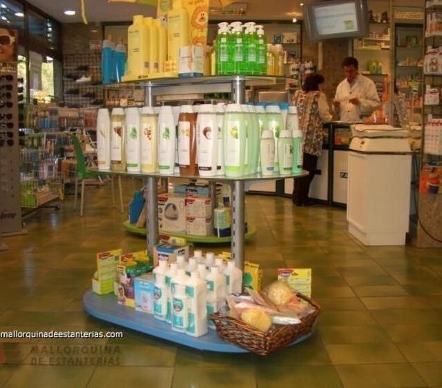 Una exposición de botellas en una farmacia con el sitio web mallorcadedamaras.com en la esquina