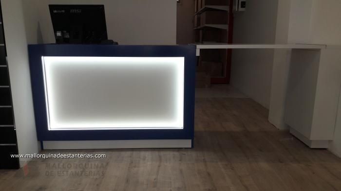 Un mostrador de recepción azul y blanco con una computadora encima.