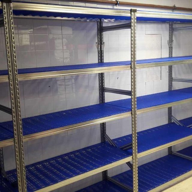 Una fila de estantes azules en una habitación con una pared blanca.