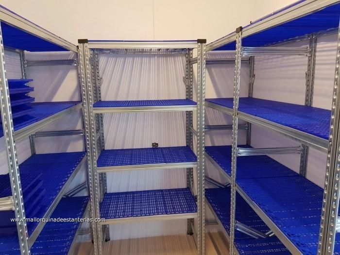 Una habitación con estantes azules y una pared blanca.