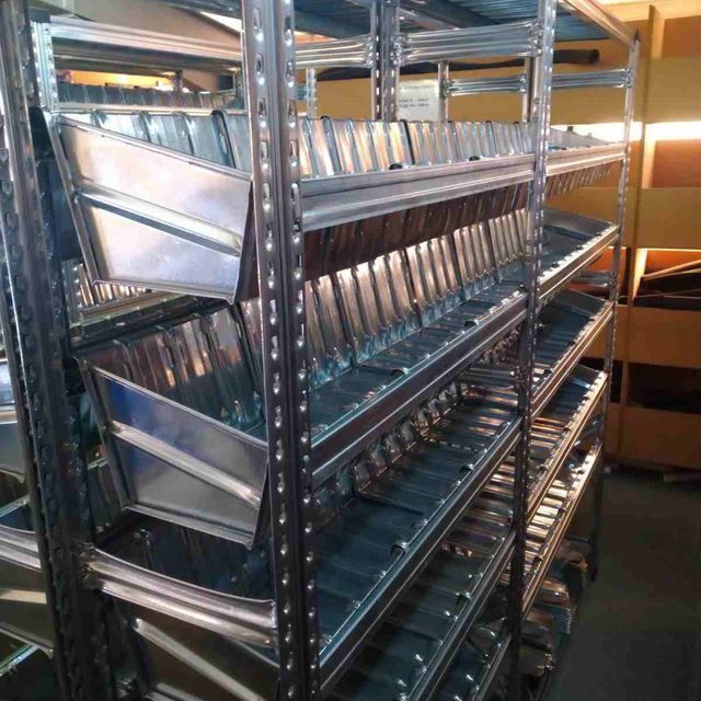 Un almacén lleno de muchos estantes y contenedores de metal.