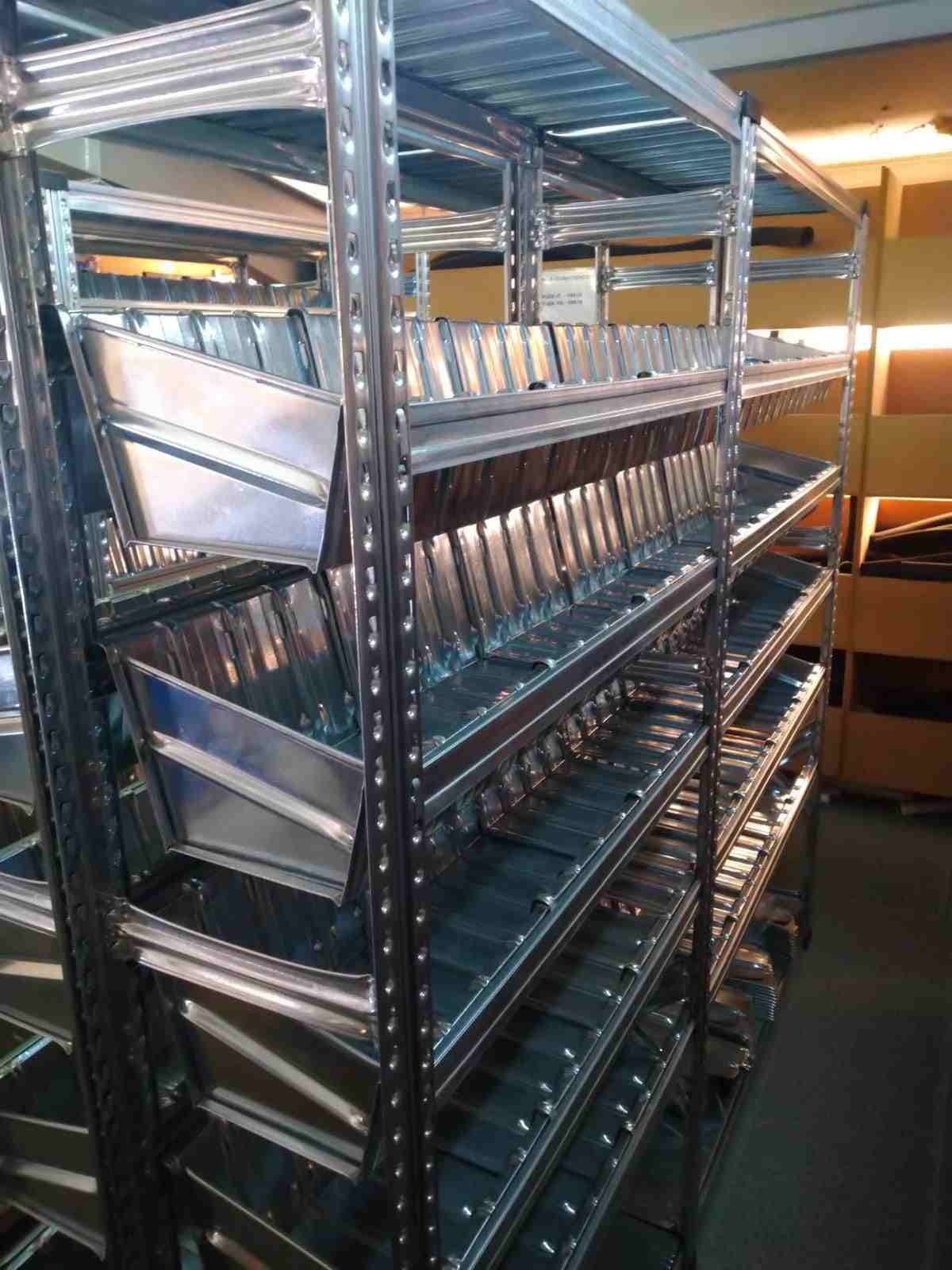 Una fila de estantes de metal llenos de cajas en un almacén.