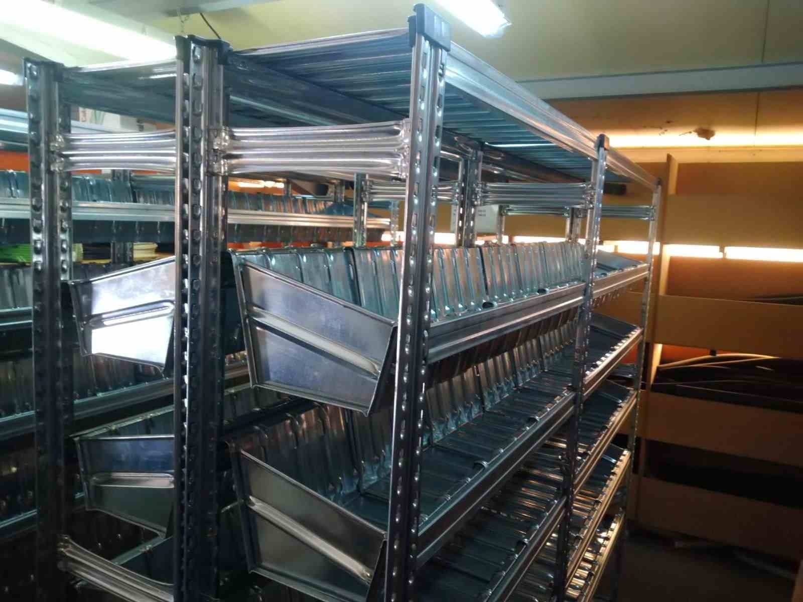 Un almacén lleno de muchos estantes y contenedores de metal.