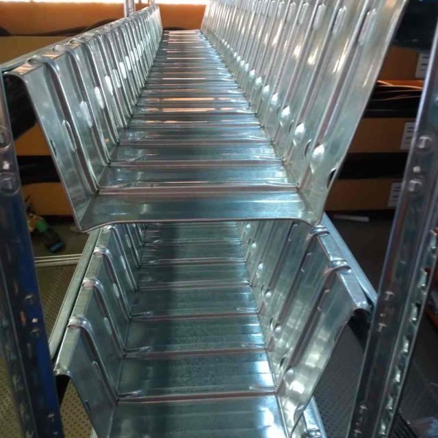 Una larga escalera de metal está colocada encima de un estante.