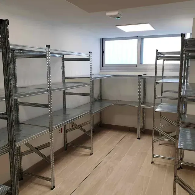 Una habitación con muchos estantes y una ventana.