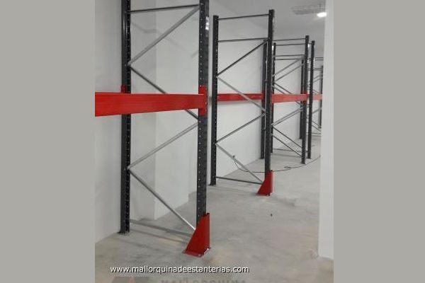 Una fila de estantes de metal en una habitación con paredes blancas.