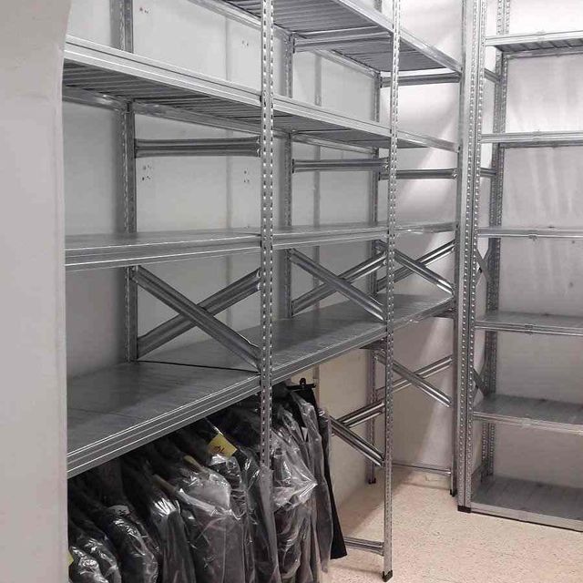 Una habitación con muchos estantes y ropa en ellos.