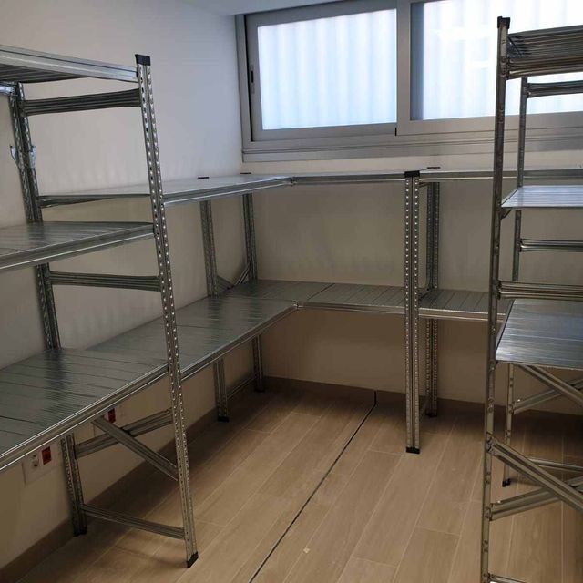 Una habitación con muchos estantes y una ventana.