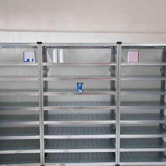 Una fila de estantes vacíos en una habitación con cajas en ellos.