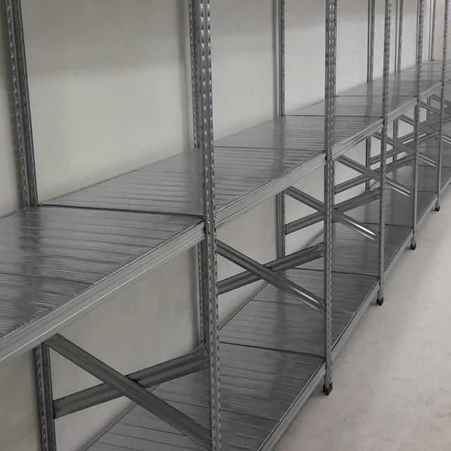 Una fila de estantes de metal contra una pared blanca.