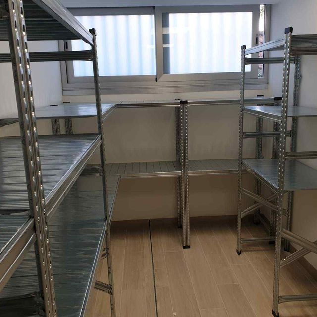 Una habitación con muchos estantes y una ventana.