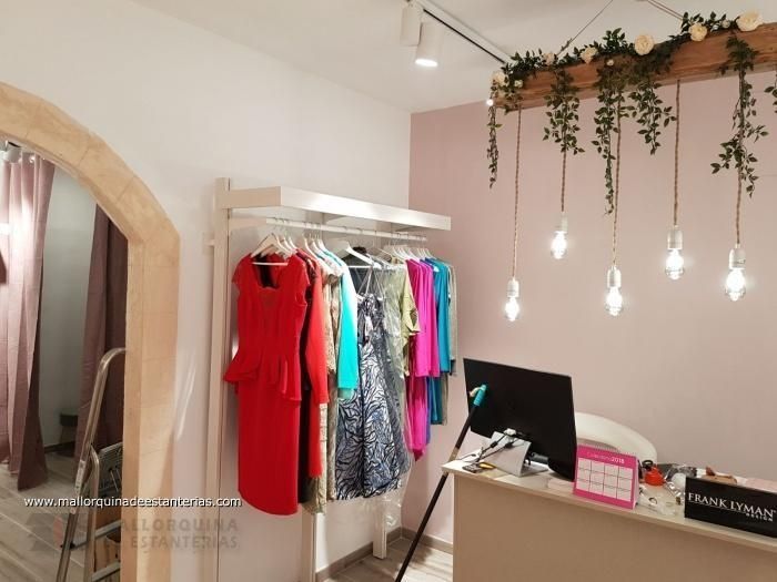 Una fila de vestidos cuelgan en un perchero en una tienda.