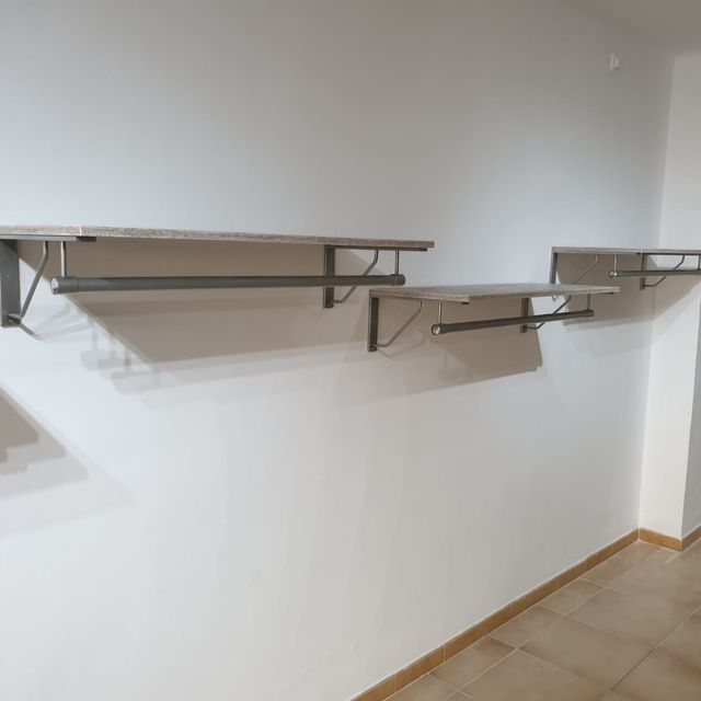 Tres estantes están colgados en una pared blanca en una habitación.