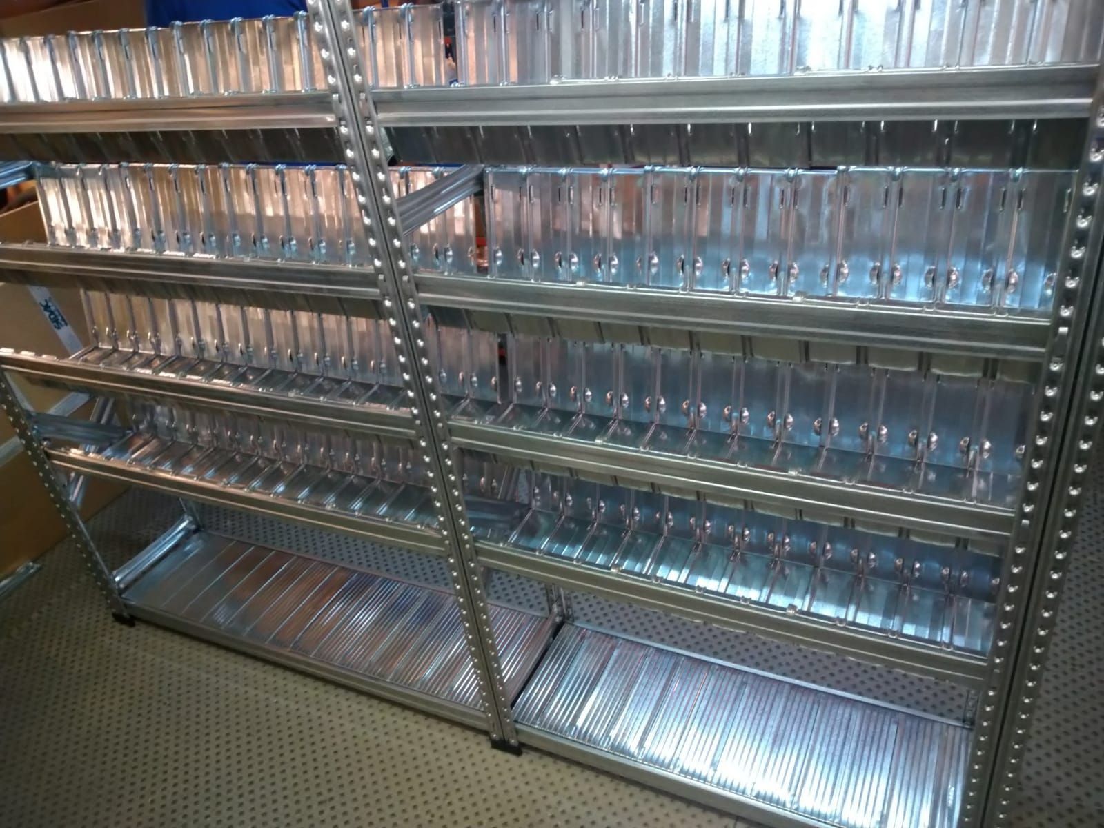 Un estante de metal lleno de muchos recipientes de plástico transparente.