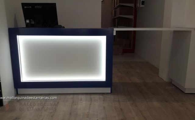 Un mostrador de recepción azul y blanco con una computadora encima.