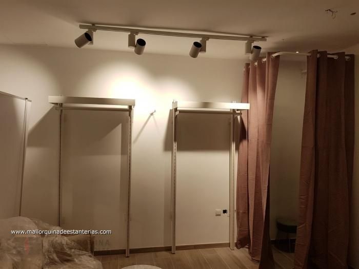 Un vestidor con cortinas rosas y un sofá.